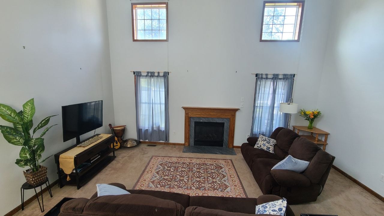 High-ceiling living room with fireplace and tall windows