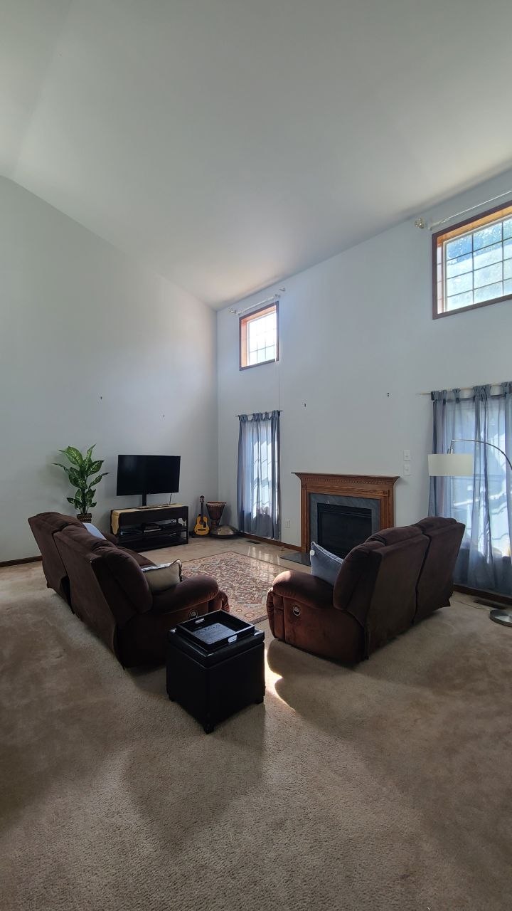 Wide-angle view across the living room toward the fireplace